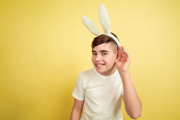 Ragazzo come un coniglietto di Pasqua sulla parete gialla dello studio