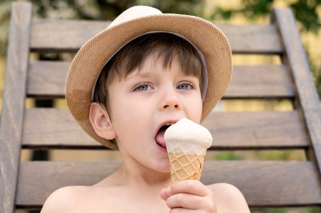 Ragazzo con cappello a mangiare il gelato