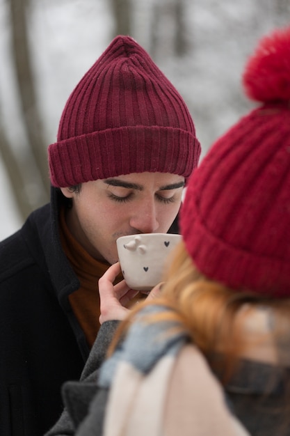 Ragazzo con cappello rosso sorseggiando da una tazza di tè