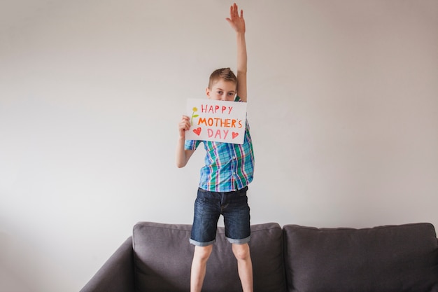 Ragazzo con il poster della madre e braccio sollevato