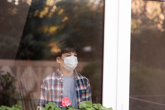 Ragazzo con la maschera per il viso a guardare all'aperto