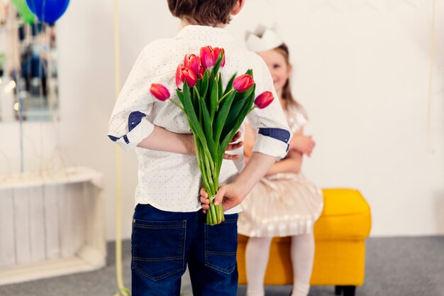 Ragazzo con tulipani rosa dietro