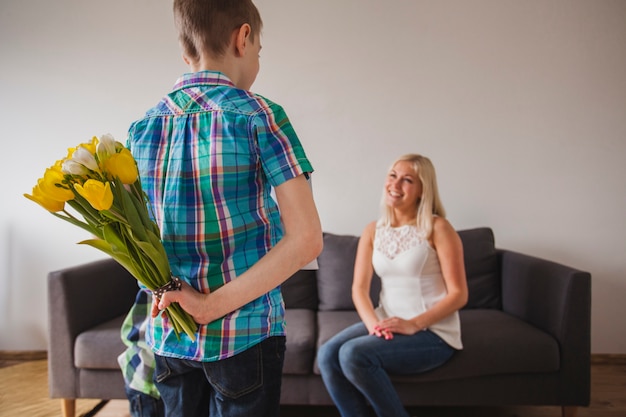 Ragazzo con un bouquet sulla schiena per la madre