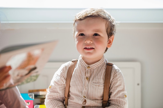 Ragazzo del bambino in camicia seduta