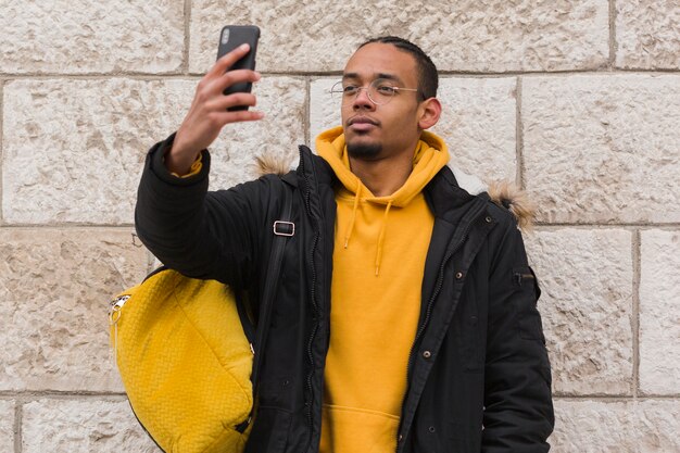 Ragazzo del tiro medio che prende un selfie