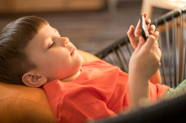 Ragazzo dell'angolo alto a casa che gioca sul cellulare