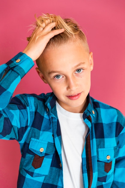 Ragazzo dell'angolo alto che sistema i suoi capelli