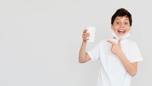 Ragazzo dello Copia-spazio che indica alla tazza di tè