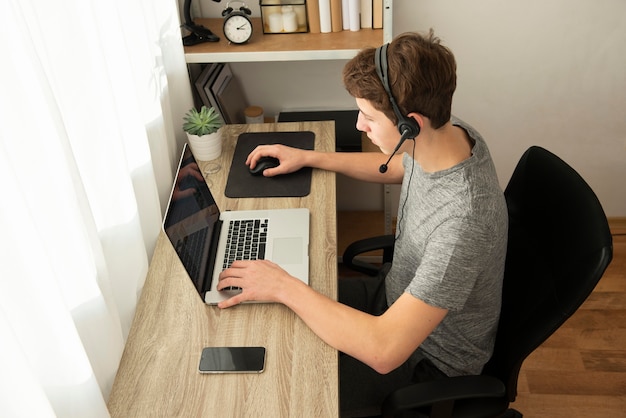 Ragazzo di alto angolo che gioca un gioco online con i suoi amici