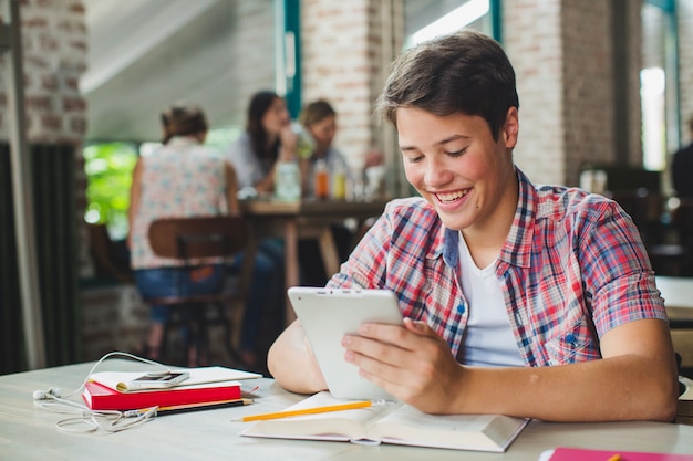 Ragazzo di contenuto con la tavoletta che studia