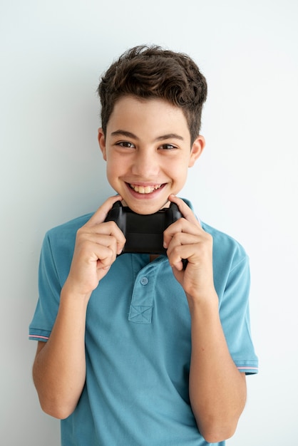 Ragazzo di tiro medio alzando un controller