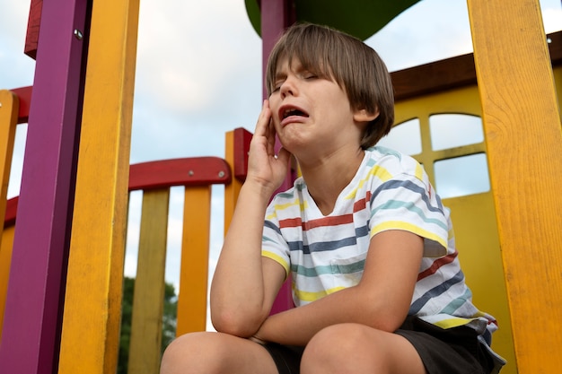 Ragazzo di tiro medio che piange nel parco