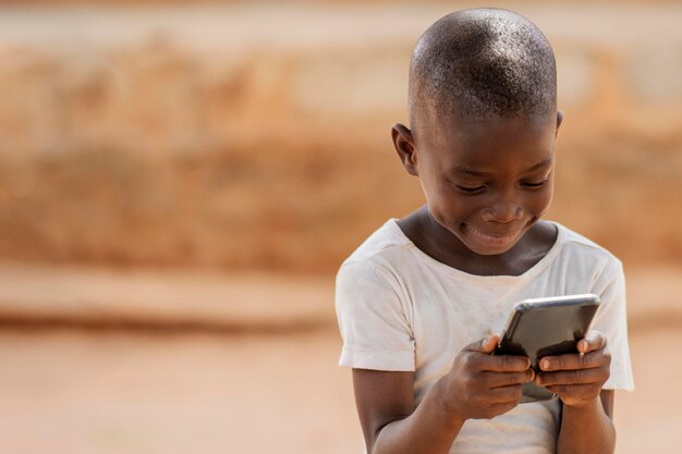 Ragazzo di tiro medio che tiene smartphone