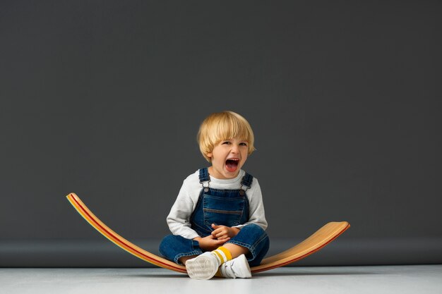 Ragazzo di vista frontale che si siede nello studio