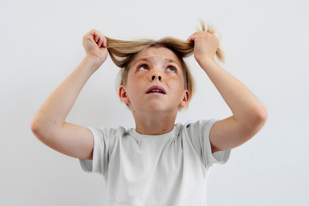 Ragazzo di vista frontale che tiene i suoi capelli