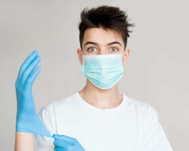 Ragazzo di vista frontale con maschera e guanti