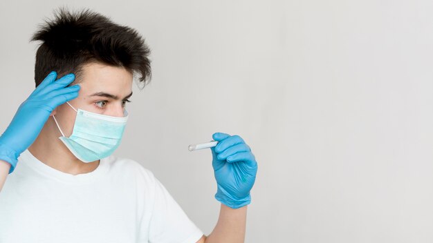 Ragazzo di vista laterale che controlla termometro