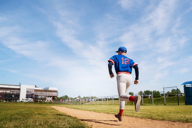 Ragazzo di vista laterale che corre sul campo