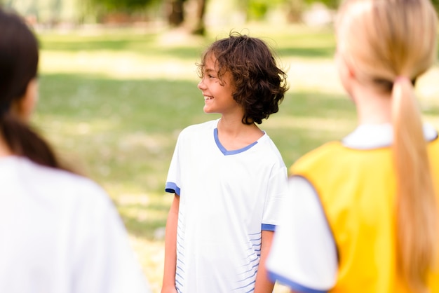 Ragazzo di vista laterale che è pronto per una partita di calcio