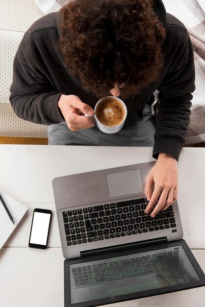 Ragazzo di vista superiore che lavora al computer portatile