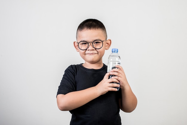 Ragazzo divertente con la bottiglia di acqua nel colpo dello studio