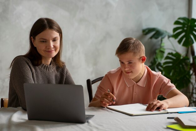 Ragazzo e donna del colpo medio con il computer portatile