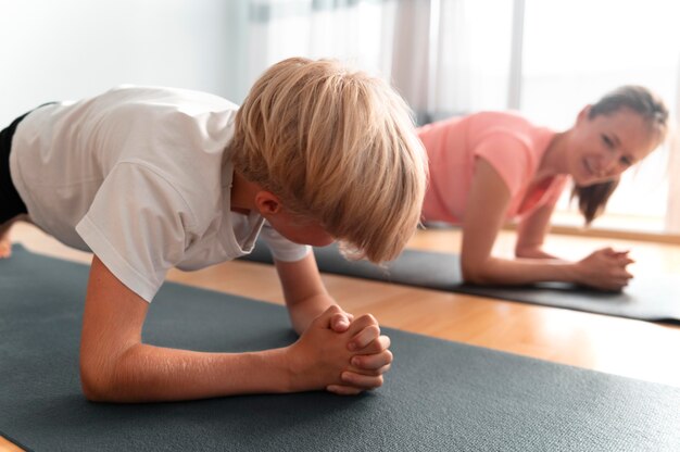 Ragazzo e donna di tiro medio con tappetini da yoga