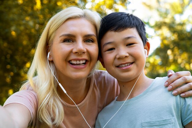 Ragazzo e donna di vista frontale che prendono selfie