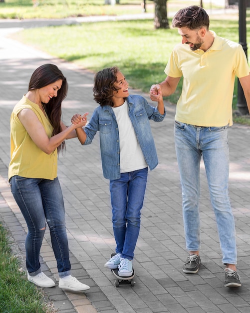 Ragazzo e genitori che camminano insieme nel parco