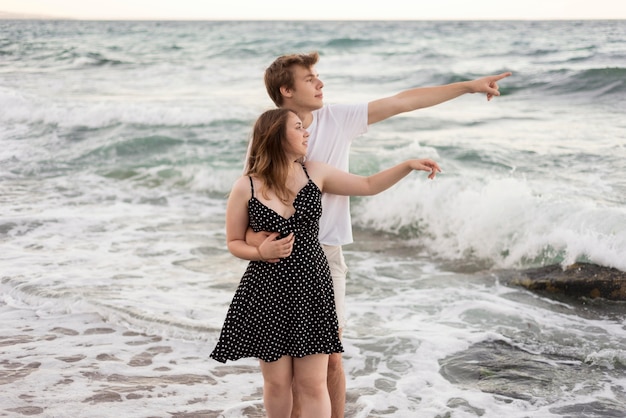 Ragazzo e ragazza che guarda lontano sulla spiaggia