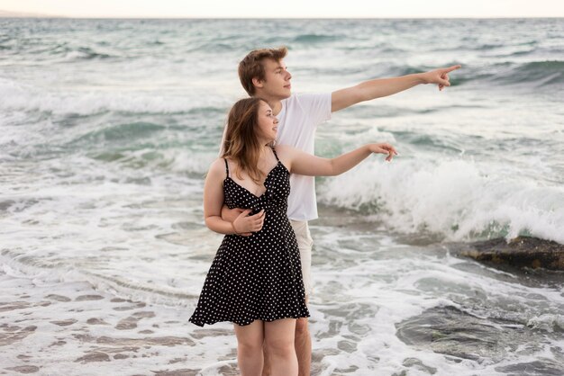 Ragazzo e ragazza che guarda lontano sulla spiaggia