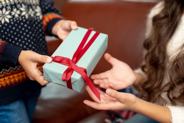 Ragazzo e ragazza del primo piano che dividono i regali