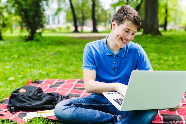 Ragazzo felice che studia nel parco