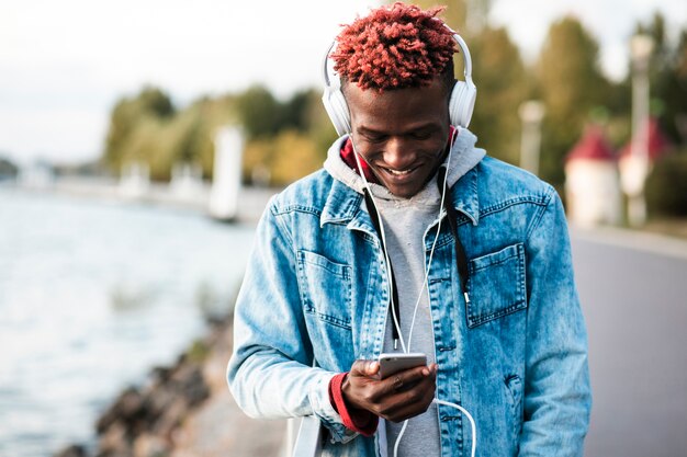 Ragazzo felice del colpo medio che esamina il suo smartphone