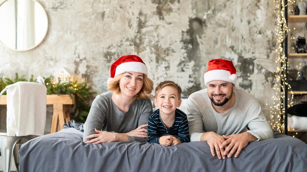 Ragazzo felice e genitori che stanno insieme il giorno di Natale
