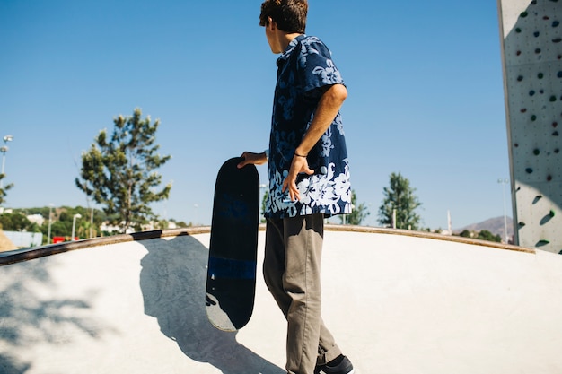 Ragazzo freddo in posa con il suo skateboard