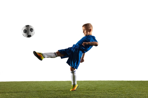 Ragazzo giovane come un giocatore di calcio o di football in abbigliamento sportivo che fa una finta o un calcio con la palla per un gol su bianco.