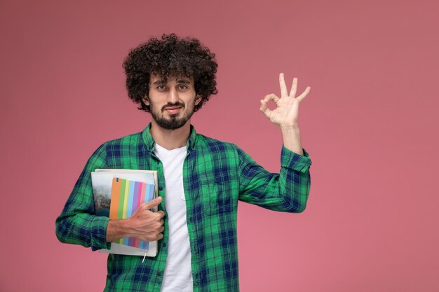 Ragazzo giovane di vista frontale che dà gesto giusto con i taccuini