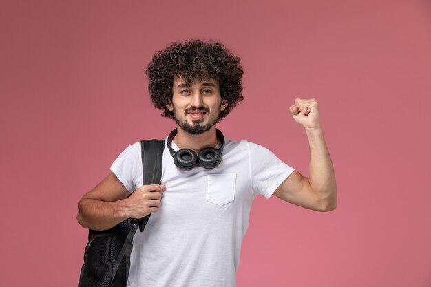 Ragazzo giovane vista frontale che mostra la sua forza e utilizzando le cuffie