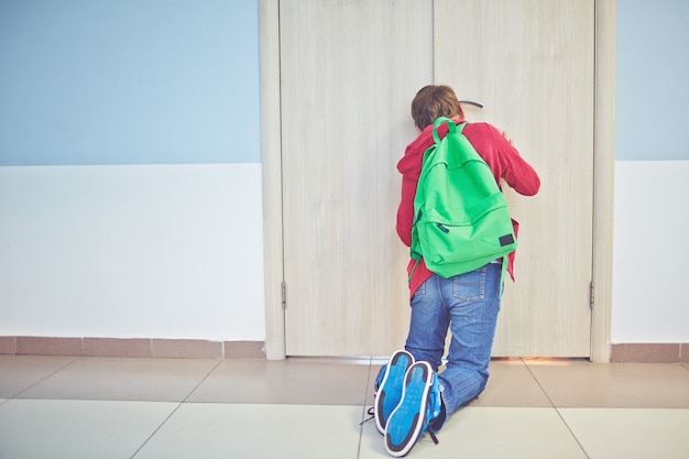 Ragazzo in ginocchio sul pavimento