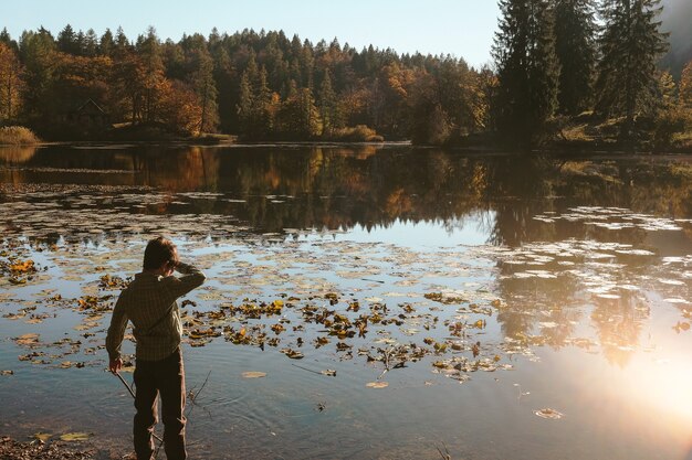 Ragazzo in piedi accanto al corpo d'acqua durante il giorno