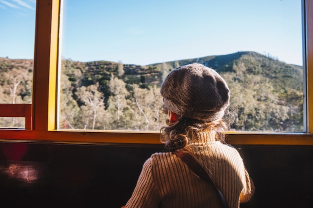 Ragazzo in piedi alla finestra in treno