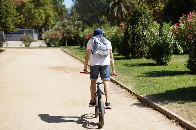 Ragazzo in sella alla sua bicicletta nel parco