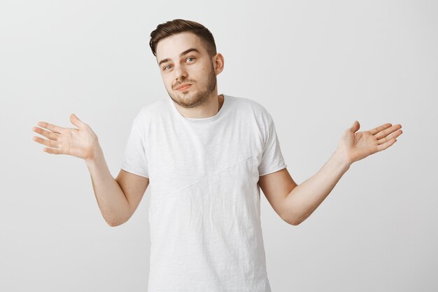 Ragazzo indifferente che scrolla le spalle con un sorriso