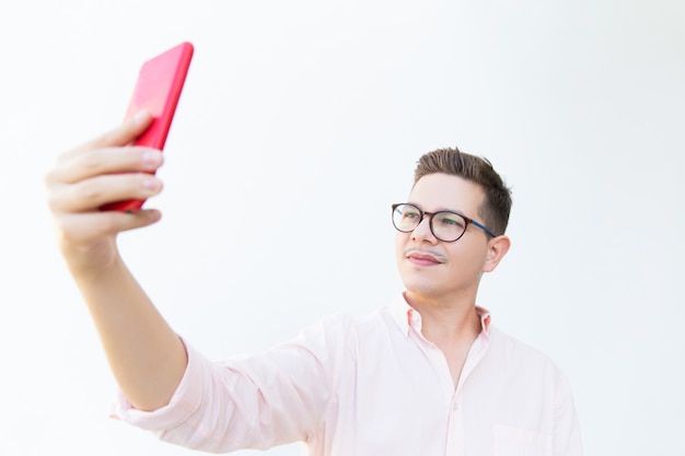 Ragazzo pensieroso messo a fuoco in occhiali che prendono selfie