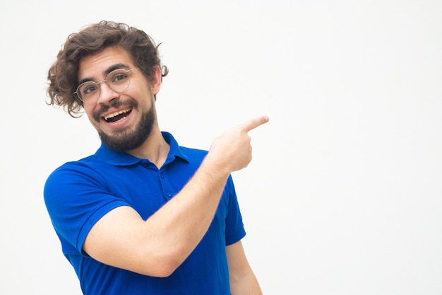 Ragazzo positivo allegro che punta il dito lontano