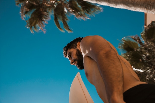 Ragazzo senza camicia con tavola da surf