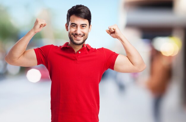 ragazzo sorridente che mostra i suoi muscoli