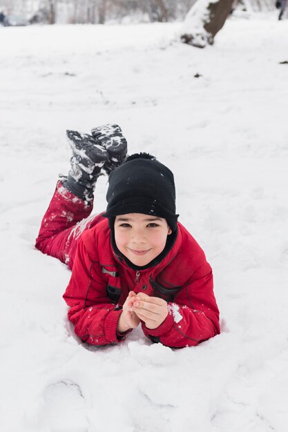 Ragazzo sorridente che si trova sul paesaggio innevato