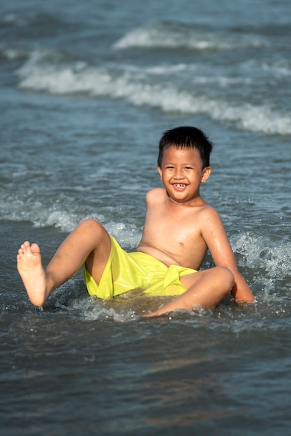 Ragazzo sorridente del colpo pieno al mare